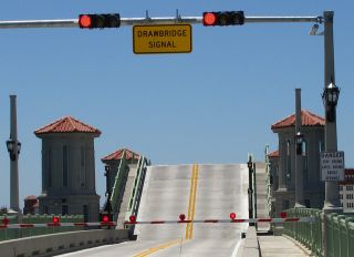 When you are approaching a drawbridge with a red signal, you must: