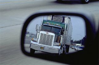 When a large truck wants to pass you, what should you do?
