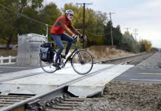 How should you cross railroad tracks safely?