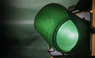 The traffic signal turns green at an intersection you are stopped at. You should: