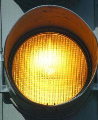 If approaching an intersection you see a steady yellow signal, you must: