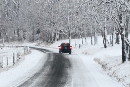 It is beginning to snow and the roadway is almost covered in snow. Any delay could cause you to miss your appointment. You should: