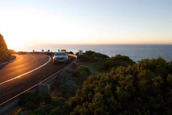 When driving at sunset or dawn on a dark day, what should you do?