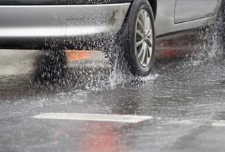 Why should you avoid heavy braking on a wet road?