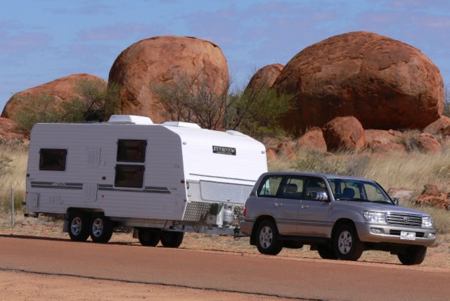 What must you do when you are towing a caravan to help other vehicles overtake?