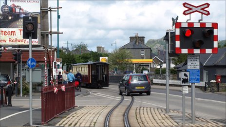 You are approaching a railway crossing which is signalling an approaching train. You should: