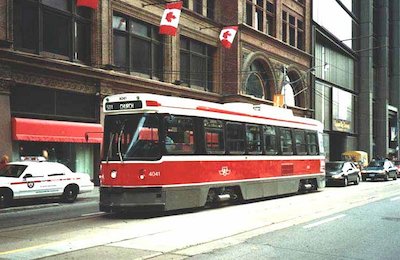 A streetcar in front of you has stopped to take on passengers. In the absence of a safety zone by law you should: