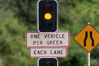 What should you do when you are coming up to traffic signals and the signals change from green to yellow?