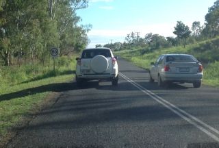 When stopped behind another vehicle on a hill, you should stay back at least: