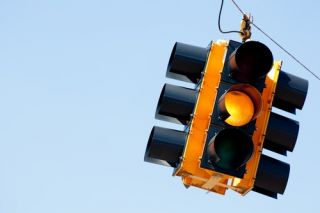 What must you do at a flashing yellow traffic signal?
