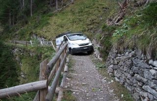 While driving up a mountain road, you meet a vehicle and there is not enough room for you to pass. What should you do?
