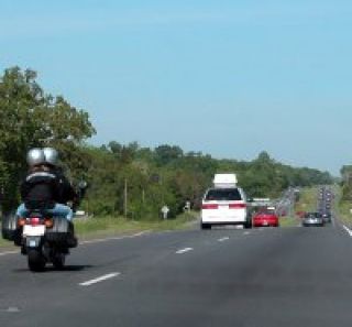 When passing a motorcyclist, drivers must:
