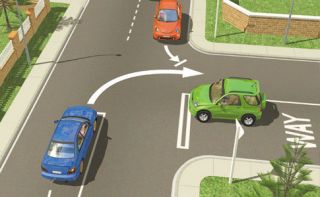 At this T intersection, which turning vehicle should give the right-of-way?