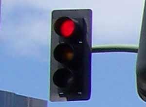 A traffic light with a flashing red signal means?