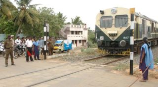 When crossing an unmanned (railway) level crossing, the driver should: